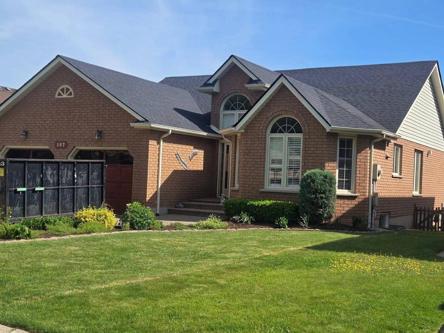 New charcoal shingle roof on a two-storey brick home in Beamsville